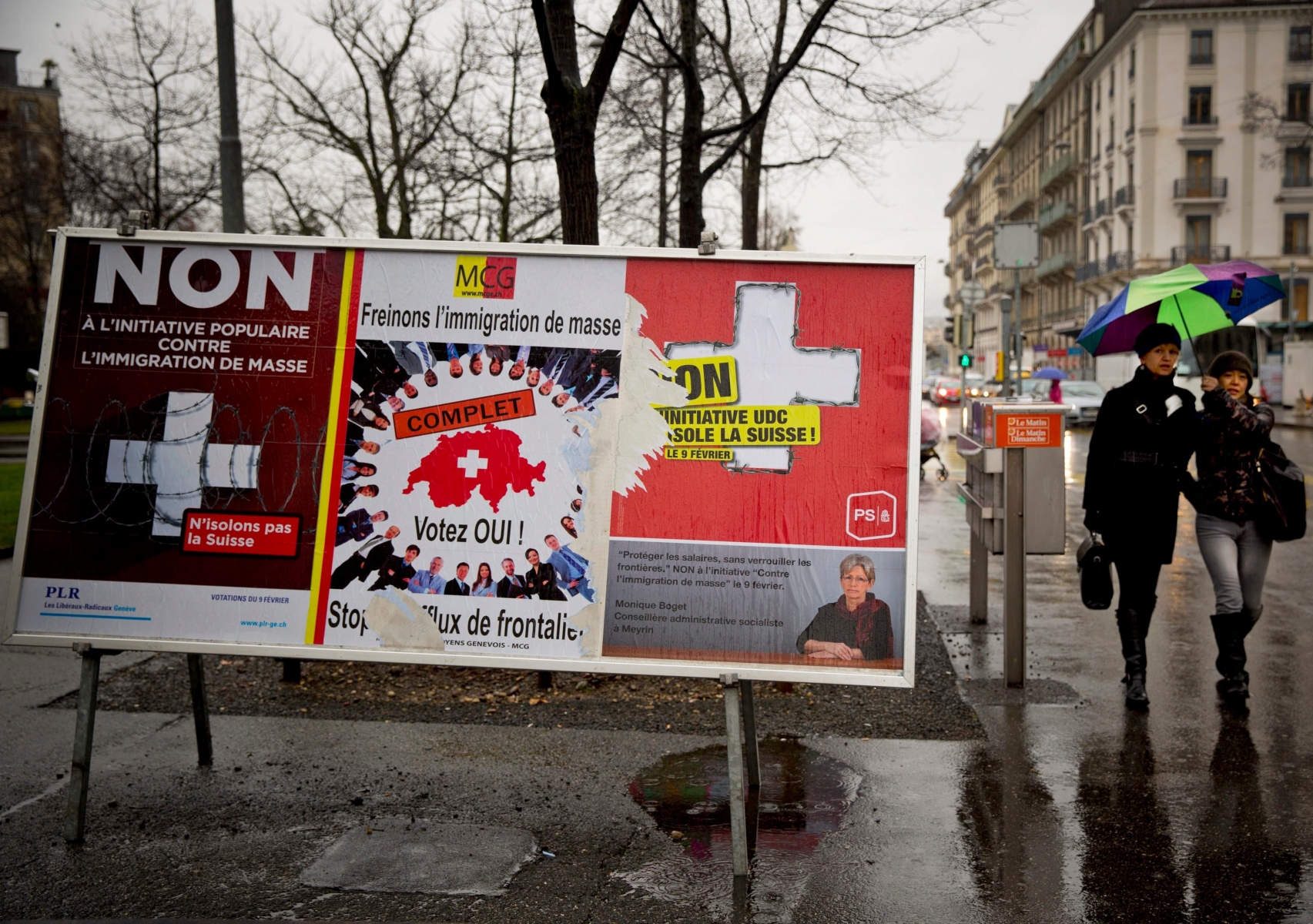 Women pass by election placards , poster in center  is  for a stop of  immigration, and posters at left and at right are for a  yes to immigration, in  Geneva, Switzerland, Monday, Feb. 10, 2014. The placard in the center reads ' stop the influence  from the border'.  The choice by Swiss voters to  reimpose curbs on immigration is sending shock waves throughout the European Union, with EU leaders on Monday warning the Swiss had violated the ìsacred principleî of Europeansí freedom of movement and politicians anxiously trying to gauge the voteís impact on burgeoning anti-foreigner movements in other countries. (AP Photo/Anja Niedringhaus) Switzerland Swiss vs Europe Switzerland Swiss vs Europe