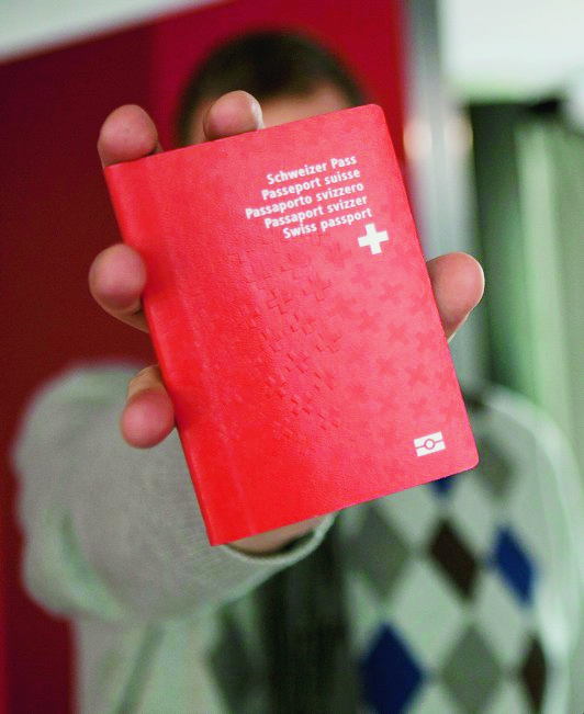 Un homme tient son nouveau passeport Suisse biometrique au nouveau centre de biometrie au Flon, ce vendredi 21 janvier 2011 a Lausanne. Ce centre va recolter les donnees biometriques pour les passeports suisse ainsi que pour les cartes de sejour biometrique. A partir du 24 janvier 2011, les titres de sejour biometriques pour les ressortissants etrangers des Etats tiers deviennent obligatoires. (KEYSTONE/Anthony Anex) SUISSE PASSEPORT NOUVEAU CENTRE BIOMETRIE