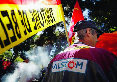 Alstom employers stage a protest in front of its headquarters in St Ouen, north of Paris, asking not to close a plant in Belfort, eastern France, which employs 400 people, Tuesday, Sept. 27, 2016. Alstom's situation is considered by many French politicians as symbolic of France's difficulty of keeping a strong industry at home. (AP Photo/Christophe Ena) France Alstom
