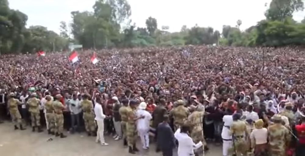 Les participants ont d'abord manifesté pacifiquement leur hostilité au gouvernement avec leurs bras croisés au-dessus de la tête, un geste devenu le symbole de la contestation des Oromo face aux autorités éthiopiennes.