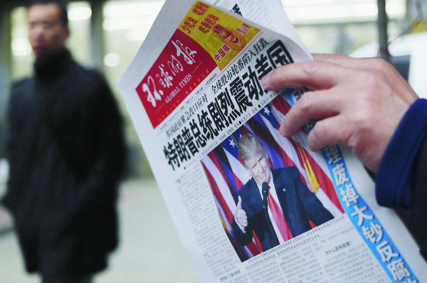 FILE - In this Nov. 10, 2016 file photo, a man reads a newspaper with the headline that reads "U.S. President-elect Donald Trump delivers a mighty shock to America" at a newsstand in Beijing. With Trump's latest tweets touching on sensitive issues, China must decide how to handle an incoming American president who relishes confrontation and whose online statements appear to foreshadow shifts in foreign policy. China awoke Monday, Dec. 5, to criticism from Trump on Twitter, days after it responded to his telephone conversation with Taiwan's president by accusing the Taiwanese of playing a "little trick" on Trump. (AP Photo/Andy Wong, File) CHINA REACTING TO TRUMP