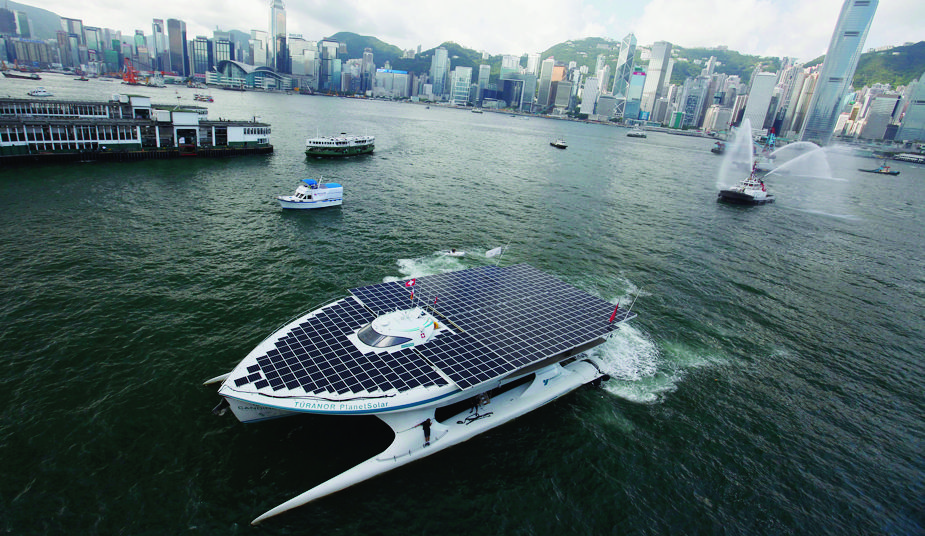 epa02867349 The Swiss-registered solar-powered vessel, 'MS Turanor Planetsolar' enters Victoria Harbour, Hong Kong, China, 15 August 2011. The solar-powered catamaran is on a record-breaking circumnavigation of the world, powered exclusively by solar energy. The journey is being touted as a travelling exhibit to highlight the use of clean energy.  EPA/ALEX HOFFORD CHINA HONG KONG SOALR POWERED BOAT