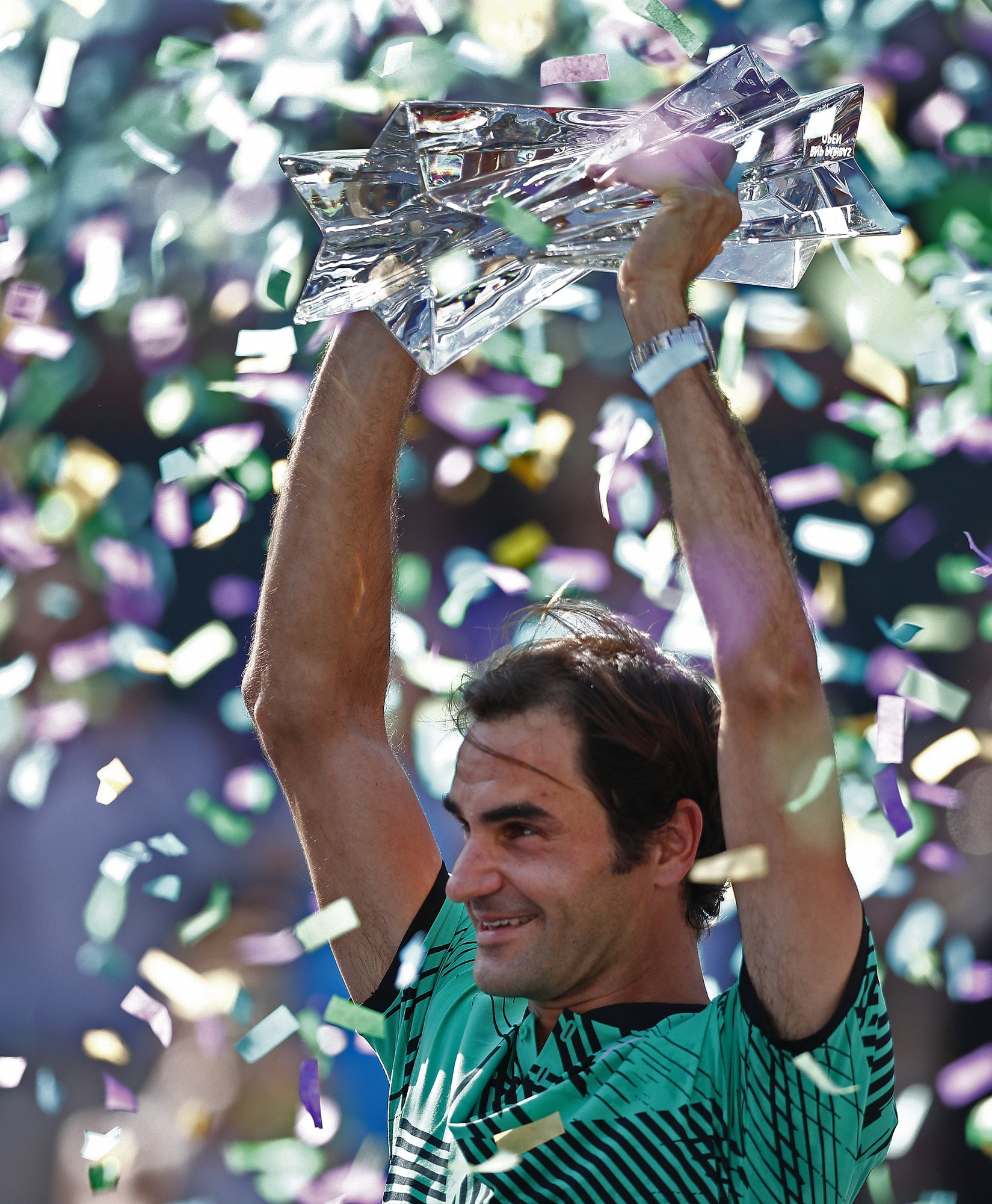 epa05858975 Roger Federer of Switzerland holds the trophy after winning the final against Stan Wawrinka of Switzerland in their finals match at the 2017 BNP Paribas Open tennis tournament at the Indian Wells Tennis Garden in Indian Wells, California, USA 19 March 2017.  EPA/LARRY W. SMITH
