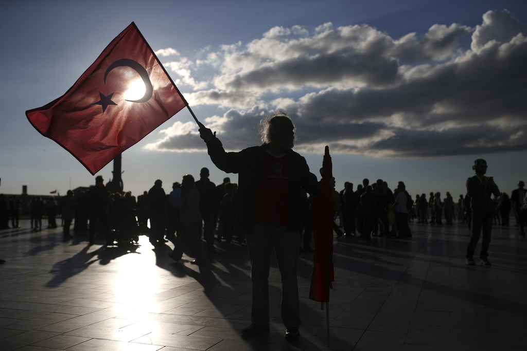A supporter of the 'no' vote, holds a Turkish flag during a protest regarding Sunday's referendum outcome, on the Aegean Sea city of Izmir, Turkey, Tuesday, April 18, 2017.  Turkey's main opposition party has filed a formal request seeking Sunday's referendum to be annulled because of alleged voting irregularities. (AP Photo/Emre Tazegul)
