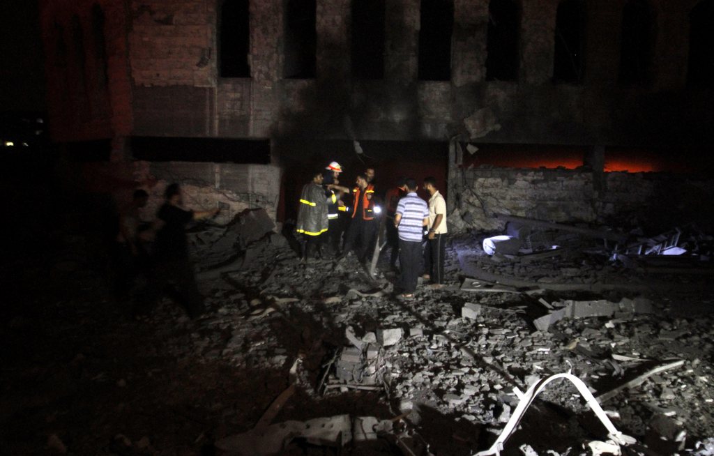Des Palestiniens inspectent les dégâts causés par les raids aériens dans la nuit de lundi à mardi sur un camp d'entraînement des services de sécurité du Hamas dans la bande de Gaza.