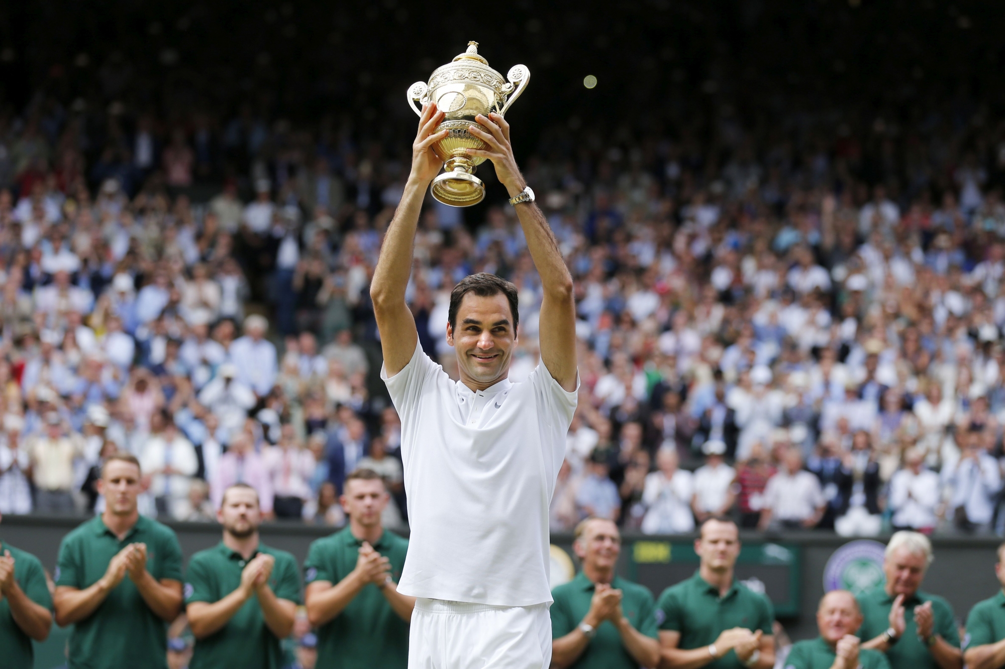 Roger Federer of Switzerland celebrates with the trophy after winning the men's final match against Marin Cilic of Croatia during the Wimbledon Championships at the All England Lawn Tennis Club, in London, Britain, 16 July 2017. (KEYSTONE/Peter Klaunzer)