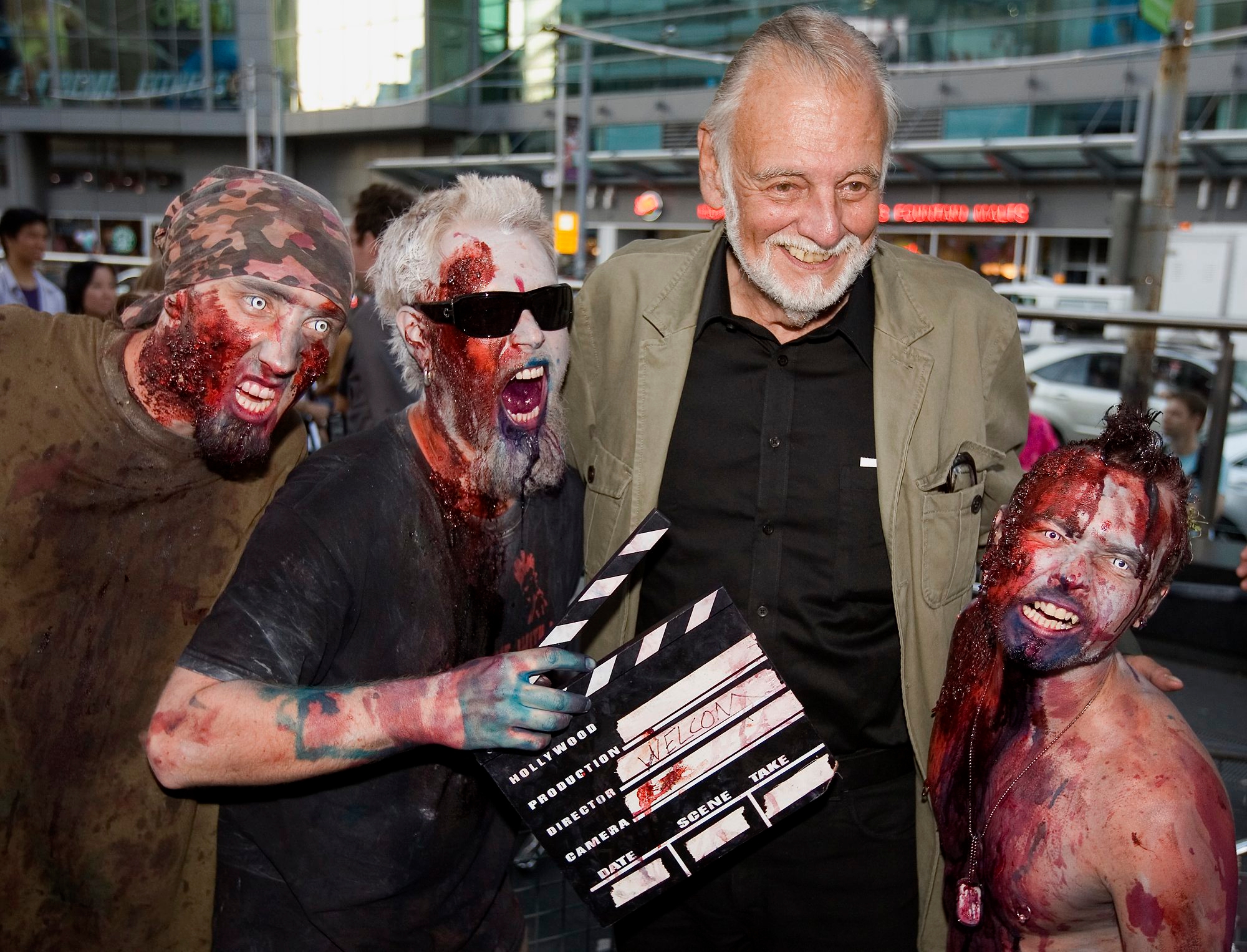 FILE - In this Sept. 12, 2009, file photo, director George Romero poses with some fans dressed as zombies after accepting a special award during the Toronto International Film Festival in Toronto. Romero, whose classic "Night of the Living Dead" and other horror films turned zombie movies into social commentaries and who saw his flesh-devouring undead spawn countless imitators, remakes and homages, has died. He was 77. Romero died Sunday, July 16, 2017, following a battle with lung cancer, said his family in a statement provided by his manager Chris Roe. (Darren Calabrese/The Canadian Press via AP, File) Obit George Romero