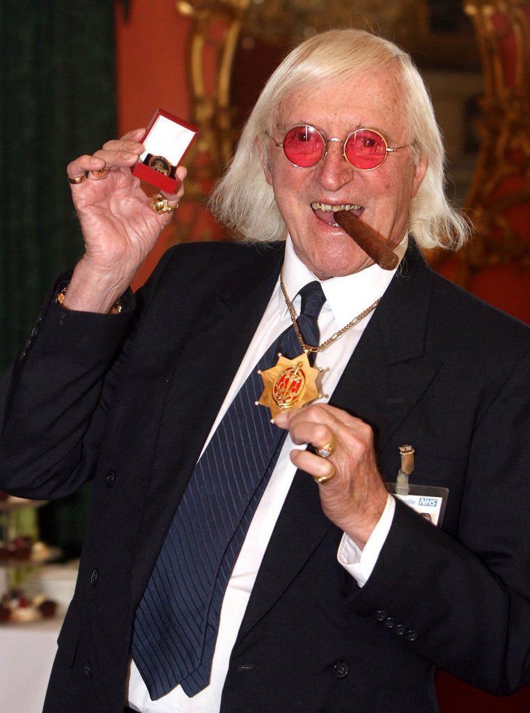FILE - This is a March 25, 2008 file photo of Sir Jimmy Savile, who for decades was a fixture on British television. A year after he died, aged 84 and honored as Sir Jimmy, several women have come forward to claim he was also a sexual predator and serial abuser of underage girls. The child abuse scandal that has enveloped the BBC, one of Britain's most respected news organizations, is now hitting one of America's, as the incoming president of The New York Times is on the defensive about his final days as head of the BBC. Mark Thompson was in charge of the BBC in late 2011 when the broadcaster shelved what would have been a bombshell investigation alleging that the late Savile was a serial sex offender. (AP Photo/ Lewis Whyld/PA, File)
