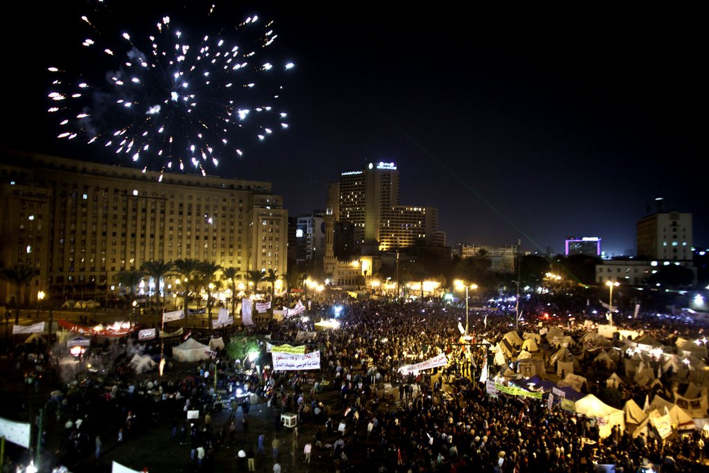 Fireworks burst over Tahrir Square as protesters gather in Cairo, Egypt, Tuesday, Dec. 4, 2012. A protest by tens of thousands of Egyptians outside the presidential palace in Cairo turned violent on Tuesday as tensions grew over Islamist President Mohammed Morsi's seizure of nearly unrestricted powers Thousands of protesters also gathered in Cairo's downtown Tahrir Square, miles away from the palace, to join several hundred who have been camping out there for nearly two weeks. (AP Photo/Maya Alleruzzo)