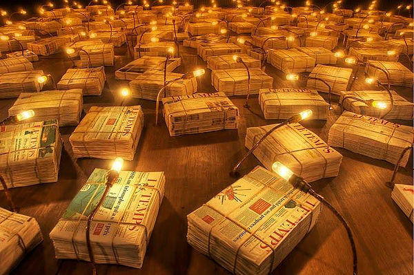 Des milliers d'exemplaires de journaux ficelés, éclairés par des lampes tamisées