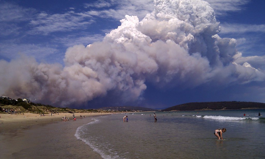 epa03523960 A bushfire smoke plume visible from Park Beach in Forcett, south-east of Hobart, Tasmania, 04 January 2013. Tasmanian police say they are not able to confirm reports of a death in a huge bushfire in Dunalley near Forcett that has already destroyed homes, a school and an RSL club.  EPA/JO GIULIANI AUSTRALIA AND NEW ZEALAND OUT