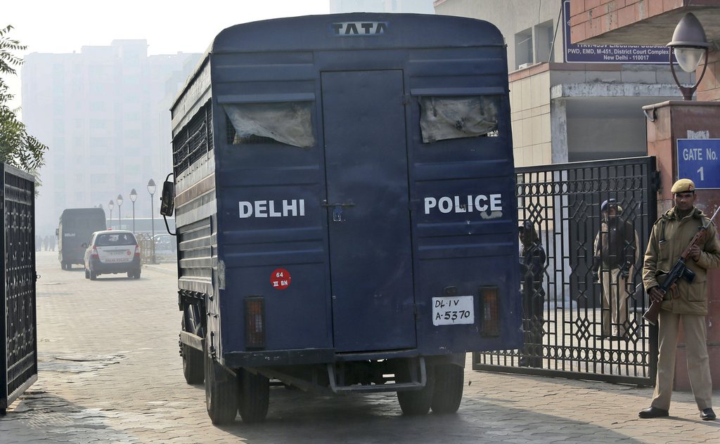 A police officer stands guard next to a  police van believed to carrying the five men accused in a gang rape as they arrive at the district court, in New Delhi, India, Monday, Jan. 7, 2013. The men, who were set to appear in court Monday, are accused of a Dec. 16 gang rape on a woman, who later died of her injuries,  that has caused outrage across India, sparking protests and demands for tough new rape laws. (AP Photo/ Manish Swarup)