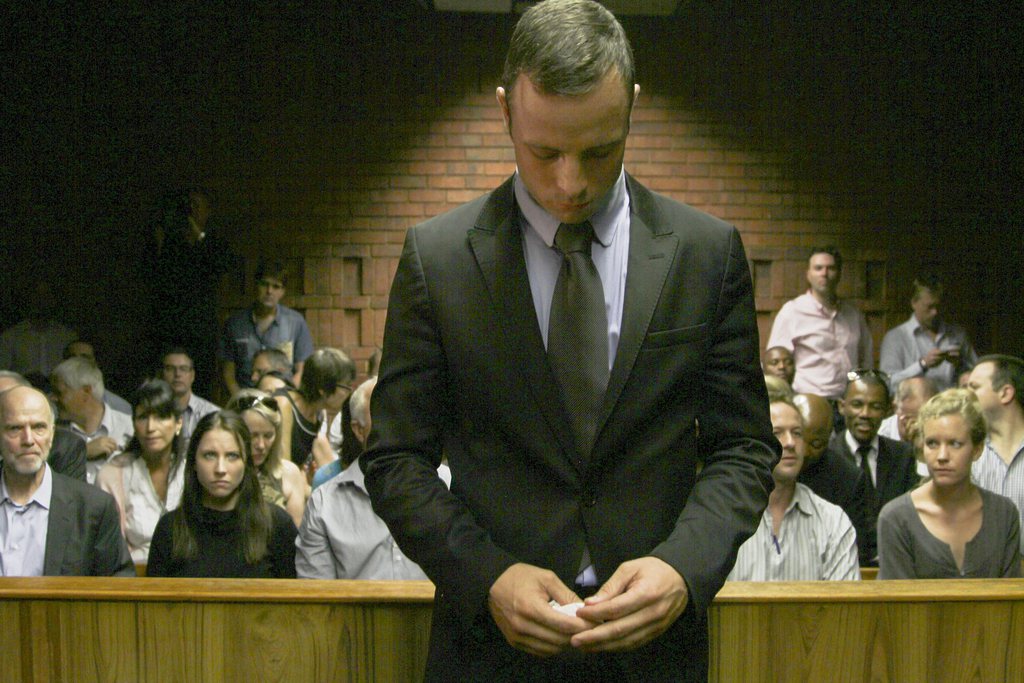 epa03593173 South African paralympian Oscar Pistorius stands in the dock at the Pretoria Magistrate's court, South Africa 21 February 2013. Pistorius is undergoing a bail hearing and is accused of murdering his girlfriend Reeva Steenkamp on Valentine's Day. Pistorius has not formally pleaded yet, but has denied the murder allegation in an affidavit.  EPA/TJ LEMON