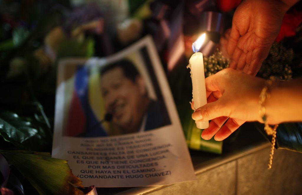 A woman places a candle in front of an image of Venezuela's President Hugo Chavez outside the Venezuela's embassy in La Paz, Bolivia, Tuesday, March 5, 2013. Bolivia's President Evo Morales decreed seven days of mourning after Venezuela's Vice President Nicolas Maduro announced that Venezuela's President Hugo Chavez died on Tuesday. (AP Photo/Juan Karita)