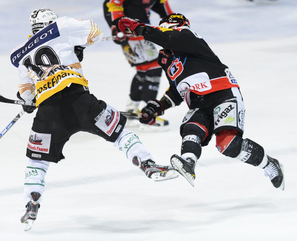 Bern's forward Tristan Scherwey, left, makes a fault against  Fribourg's forward Benjamin Pluess, right, during the first leg of the Playoff-finals game of the National League A Swiss Championship between the HC Fribourg-Gotteron and the SC Bern at the ice stadium BCF-Arena in Fribourg, Switzerland, Thursday, April 4, 2013. (KEYSTONE/Laurent Gillieron)