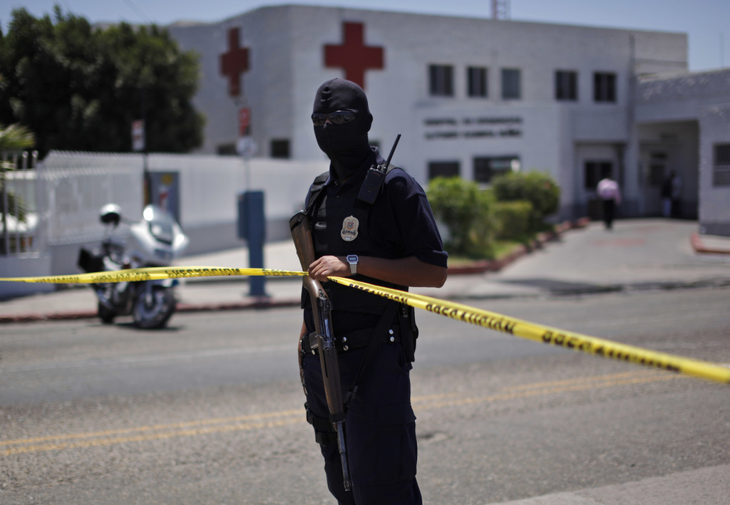 A police officer stands guard at the site where fellow police officer Eva Gonzalez was shoot outside the Red Cross bulding in Tijuana, Mexico, Tuesday, July 7, 2009. (AP Photo/Guillermo Arias)