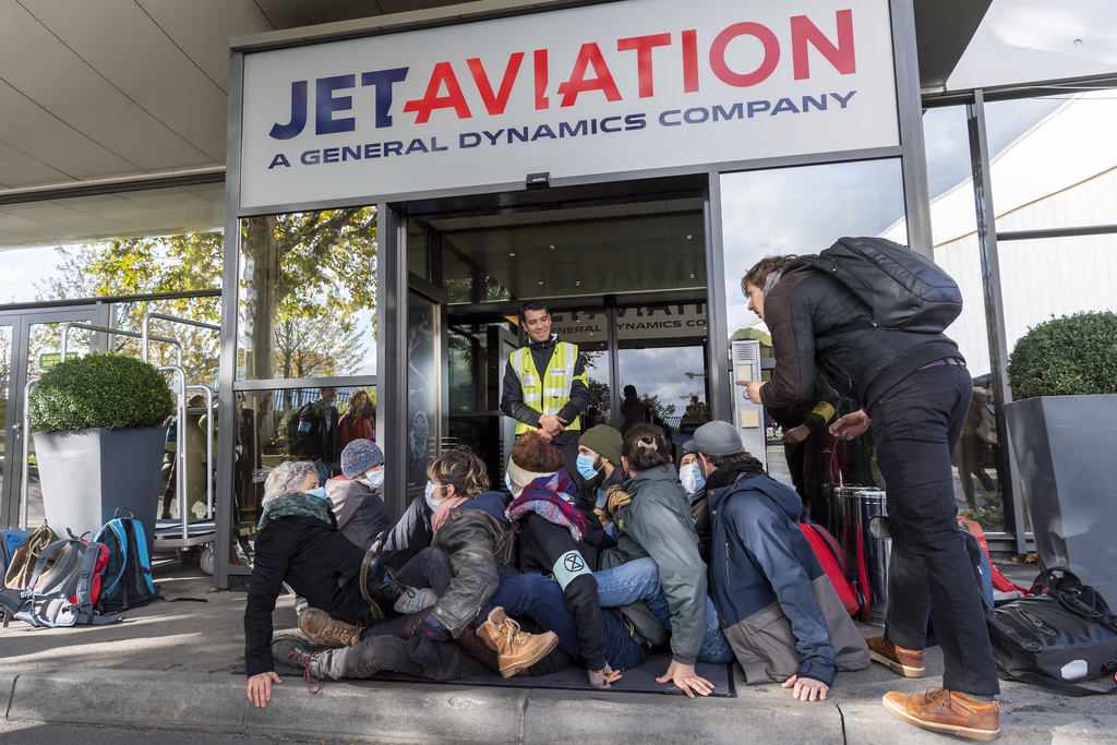 Extinction Rebellion climate change activists block an entrance to general aviation terminal at the Geneva Airport, in Geneva, Switzerland, Saturday, November 16, 2019. (KEYSTONE/Martial Trezzini)